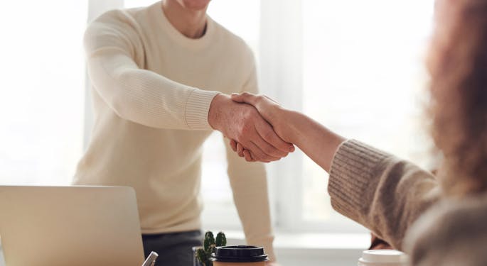 An employer and employee shaking hands.