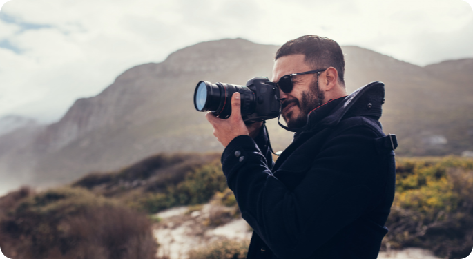 A man shooting landscape photos on a camera.